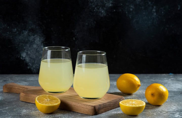 lemons and glasses of lemon water | side effects of drinking too much lemon water