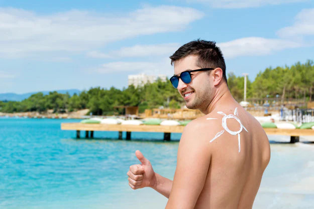 A man doing thumbs near the beach | sunscreen for men