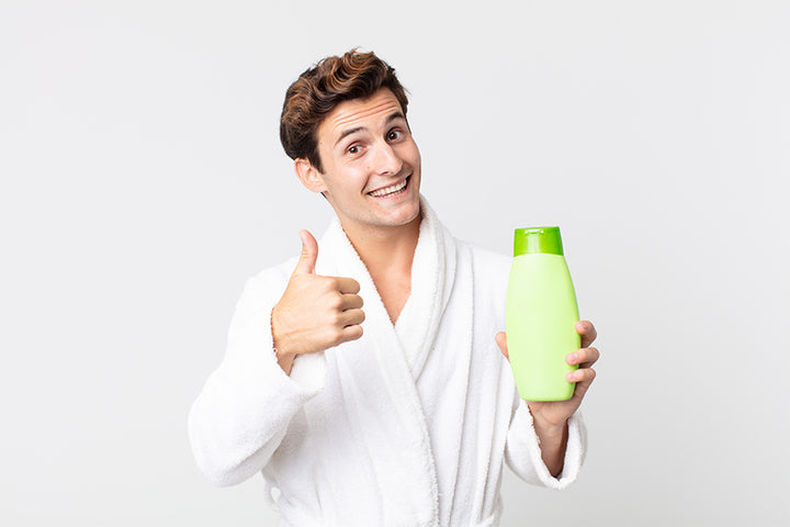 A man thumbing up holding a shampoo bottle | Everything you need to know about keto shampoo