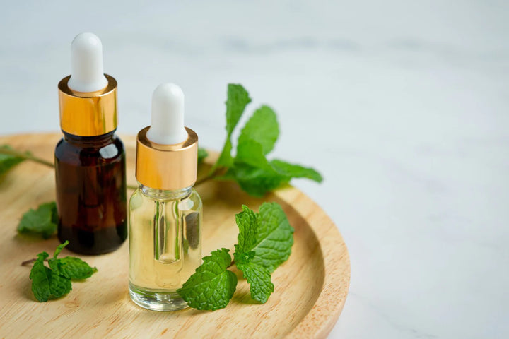 Oil bottles and leaves in a tray | peppermint oil benefits for hair