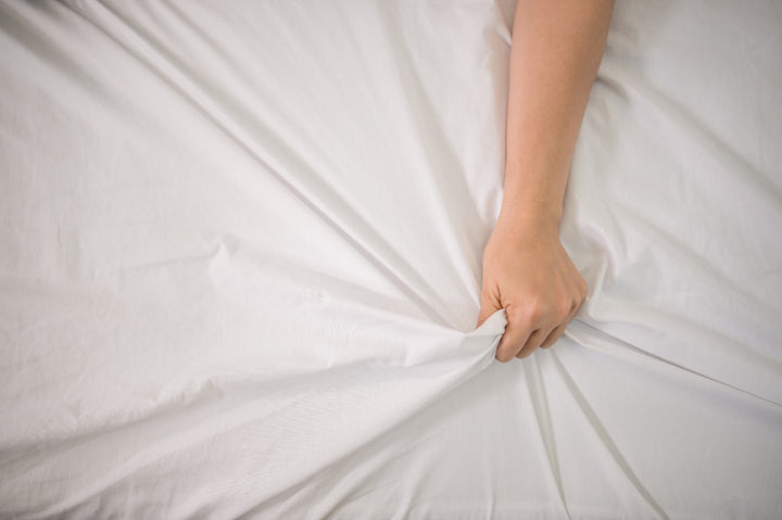 a person holding a bedsheet tightly