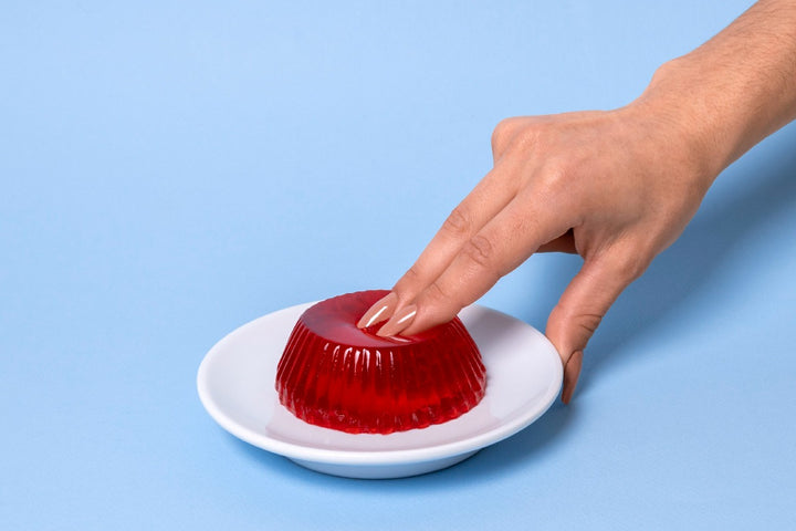 a woman's hand pressing a jelly in a sensual manner