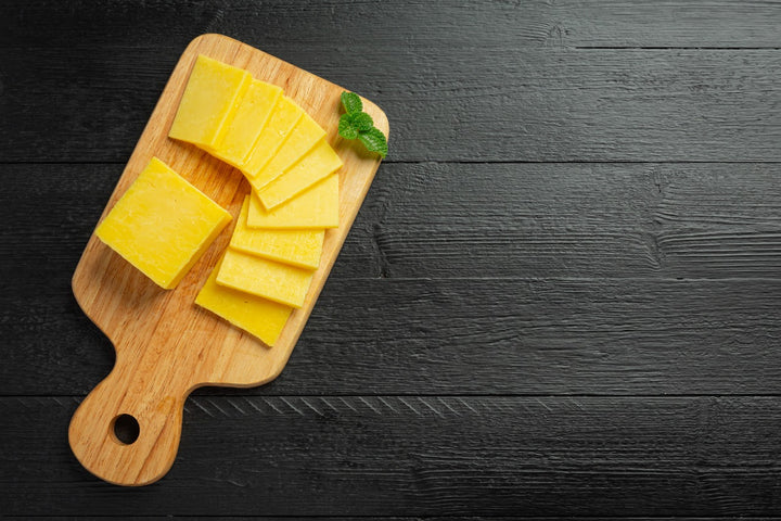 slices of cheese are kept on a chopping board